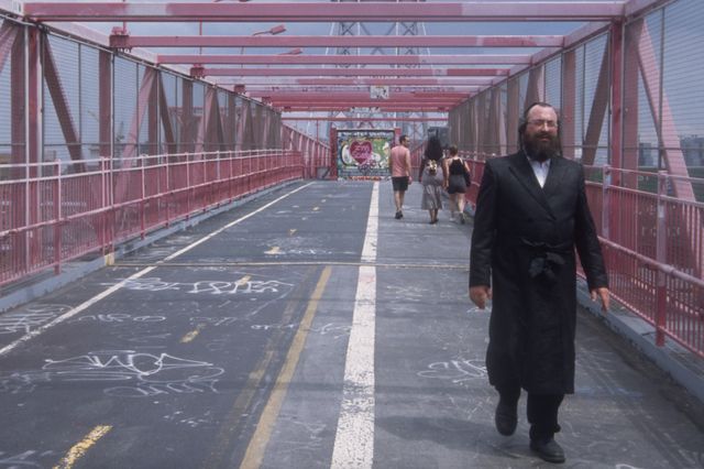 a Hasidic man crosses the Williamsburg Bridge